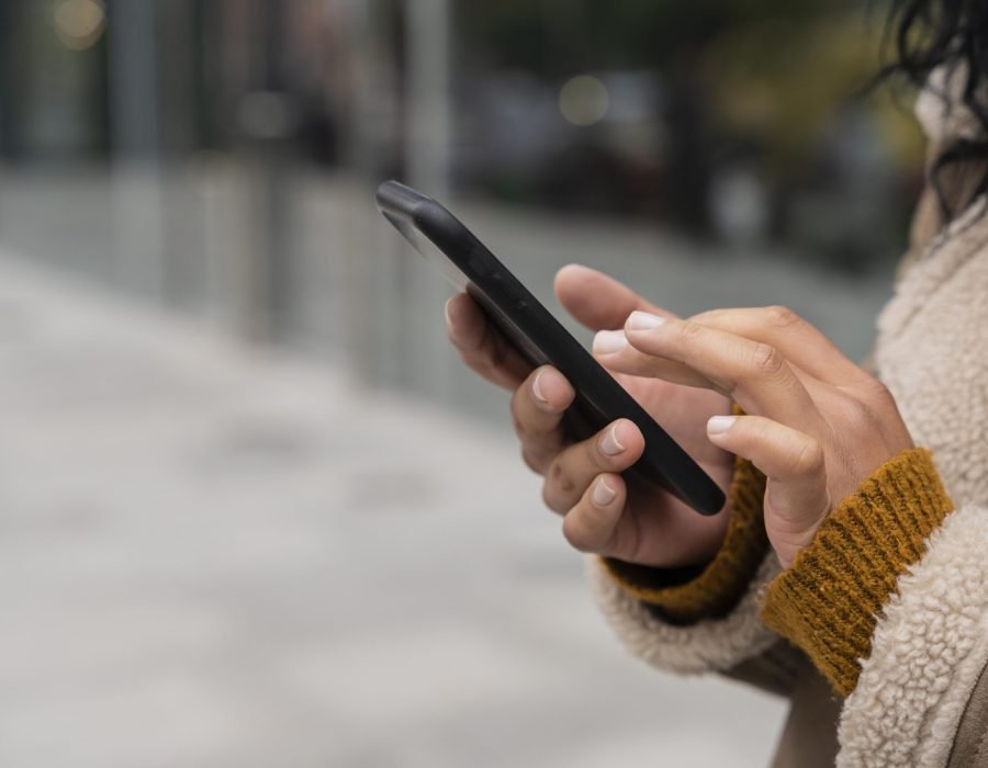 mulher-usando-seu-smartphone-lado-de-fora-com-espaco-de-copia