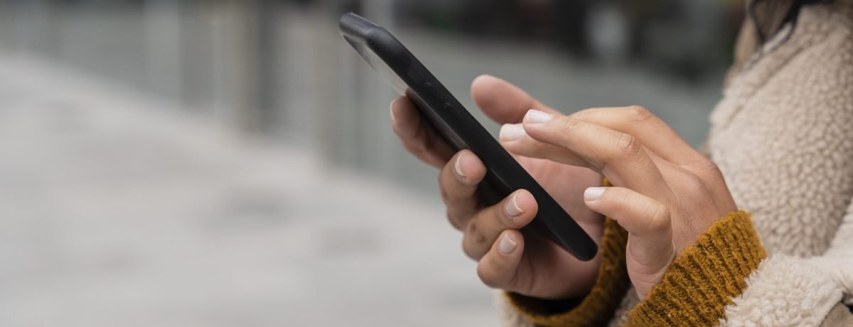 mulher-usando-seu-smartphone-lado-de-fora-com-espaco-de-copia